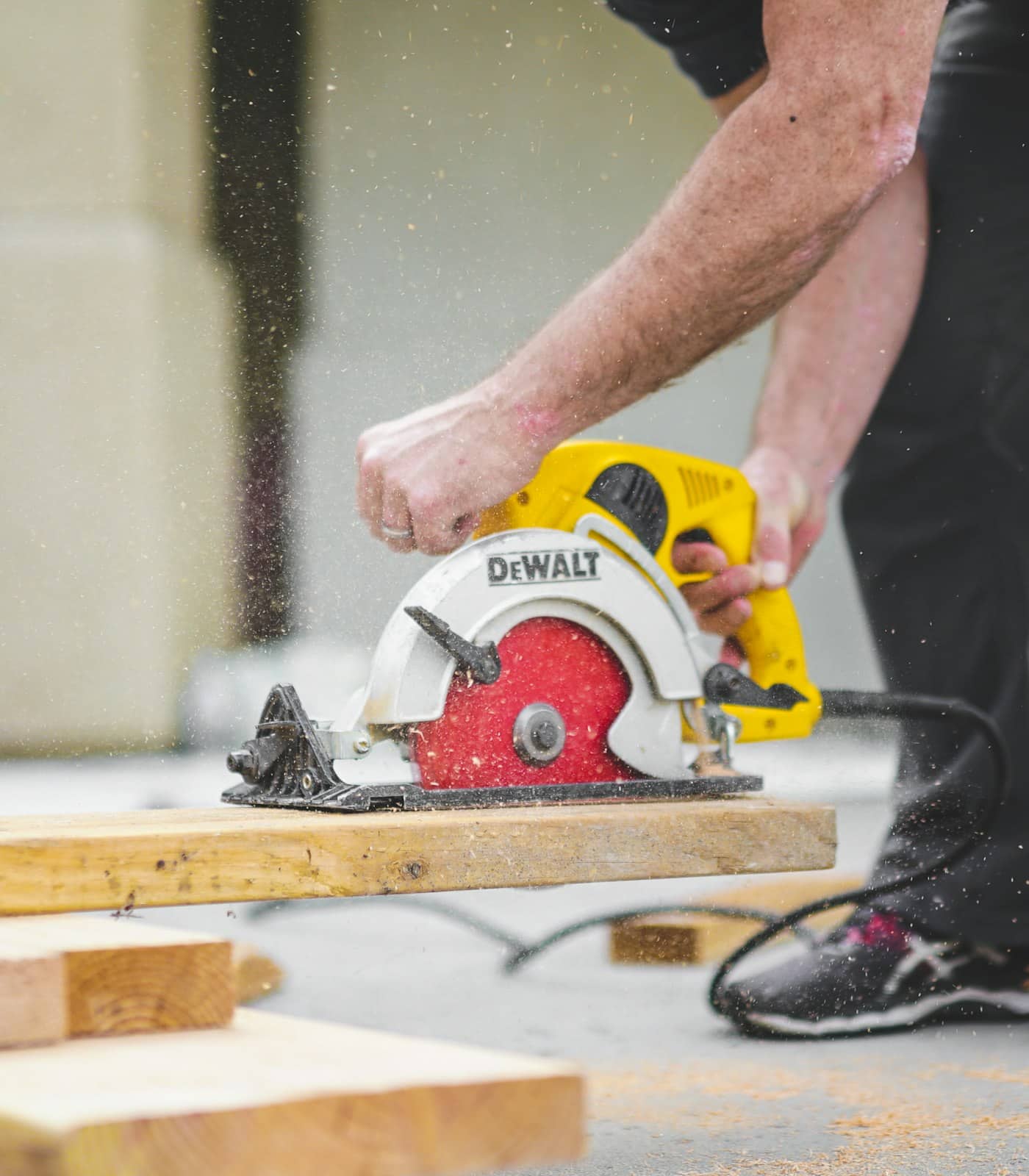 Carpenter cutting timber with a circular saw on a build site